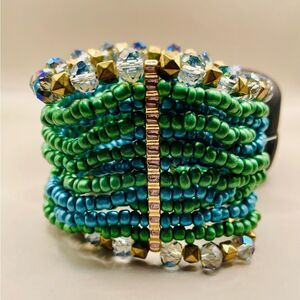 Turquoise mixed media beaded bracelet. Gold tone metal rods hold the beaded rows
